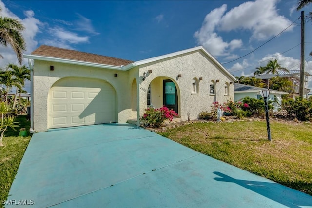 2692 Clyde St, Matlacha, FL 33993 - mediterranean / spanish house with concrete driveway, a garage, stucco siding, and a front yard