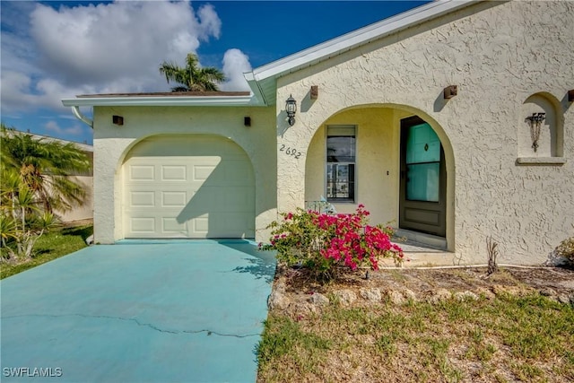 2692 Clyde St, Matlacha, FL 33993 - view of front of property featuring concrete driveway, a garage, and stucco siding