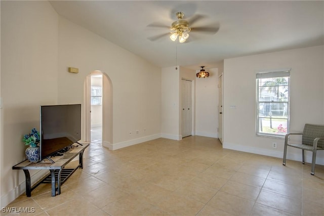 2692 Clyde St, Matlacha, FL 33993 - living room with arched walkways, a ceiling fan, light tile patterned floors, and baseboards