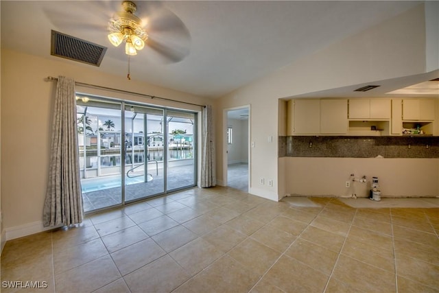 2692 Clyde St, Matlacha, FL 33993 - spare room with vaulted ceiling, a ceiling fan, light tile patterned floors, and baseboards
