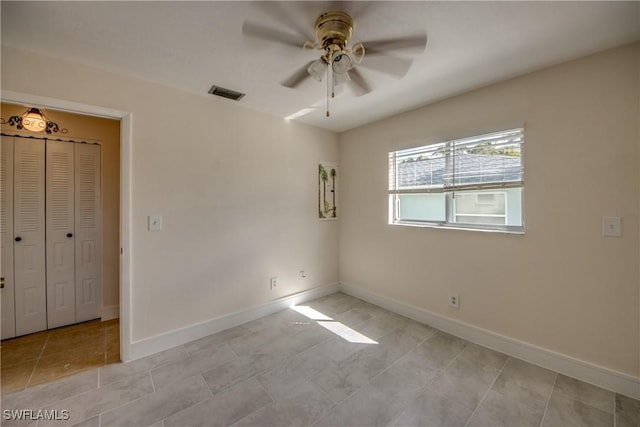 2692 Clyde St, Matlacha, FL 33993 - unfurnished bedroom with baseboards, light tile patterned floors, a ceiling fan, and a closet