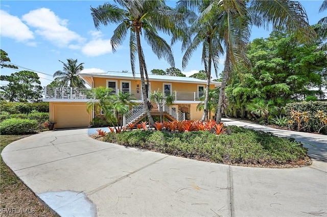 4680 Key Largo Ln, Bonita Springs, FL 34134 - view of front of property featuring stairway, an attached garage, concrete driveway, and stucco siding