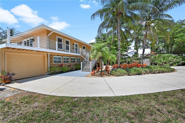 4680 Key Largo Ln, Bonita Springs, FL 34134 - view of front of property with concrete driveway, a garage, stairs, and stone siding