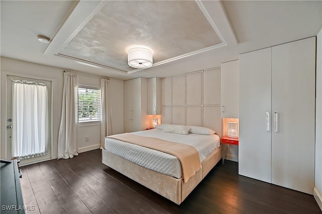 4680 Key Largo Ln, Bonita Springs, FL 34134 - bedroom featuring dark wood-style flooring, a raised ceiling, and baseboards