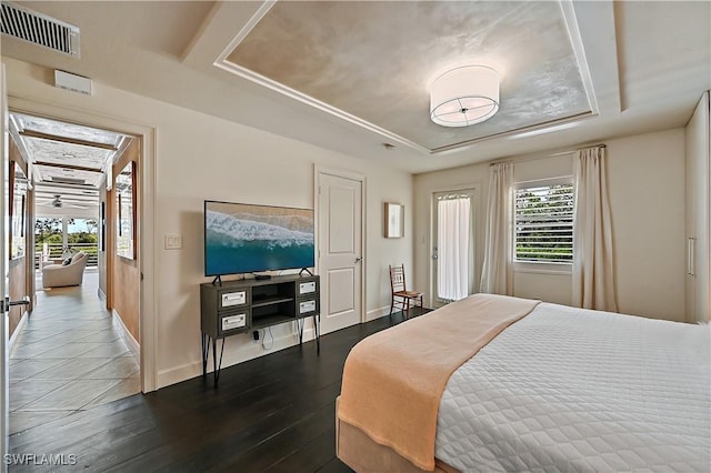 4680 Key Largo Ln, Bonita Springs, FL 34134 - bedroom featuring a tray ceiling, multiple windows, dark wood finished floors, and baseboards