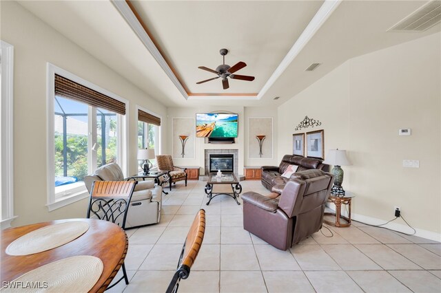 4009 Chiquita Blvd S, Cape Coral, FL 33914 - living area featuring a ceiling fan, a tiled fireplace, light tile patterned floors, and a tray ceiling