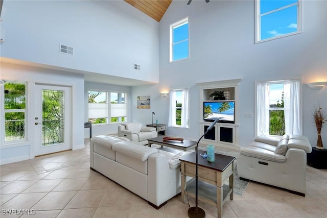 654 Sea Oats Dr, Sanibel, FL 33957 - living room with high vaulted ceiling, light tile patterned floors, wooden ceiling, and baseboards