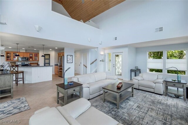 654 Sea Oats Dr, Sanibel, FL 33957 - living area with high vaulted ceiling, wooden ceiling, recessed lighting, light tile patterned floors, and stairway