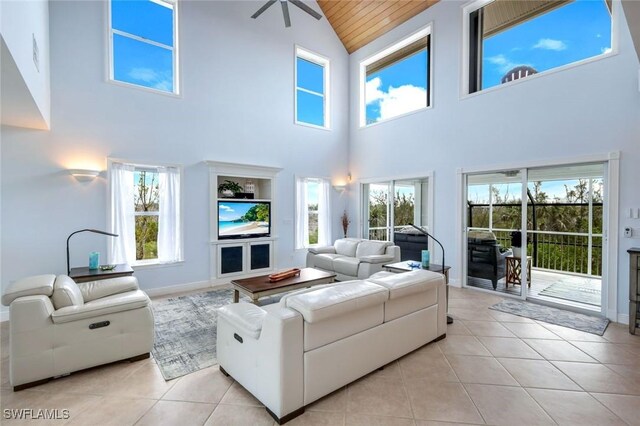 654 Sea Oats Dr, Sanibel, FL 33957 - living area with high vaulted ceiling, light tile patterned floors, wood ceiling, baseboards, and ceiling fan