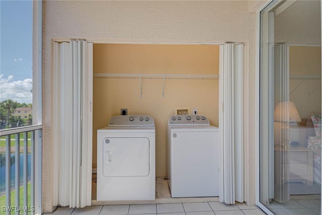 14931 Park Lake Dr Unit 209, Fort Myers, FL 33919 - laundry area with independent washer and dryer, tile patterned floors, and a textured wall