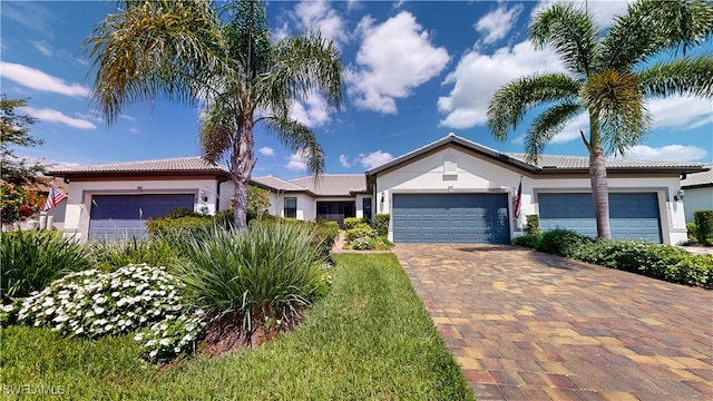 5872 Mayflower Way, Ave Maria, FL 34142 - ranch-style house with stucco siding, an attached garage, decorative driveway, and a tiled roof