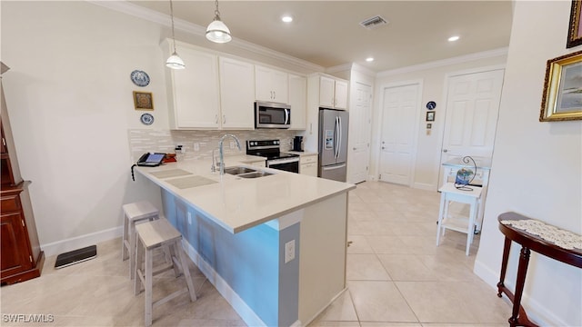 5872 Mayflower Way, Ave Maria, FL 34142 - kitchen with stainless steel appliances, a sink, light countertops, a breakfast bar area, and decorative backsplash