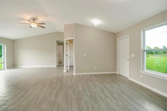 1143 Florence St E, Lehigh Acres, FL 33974 - empty room with light wood-style floors, a ceiling fan, plenty of natural light, and lofted ceiling