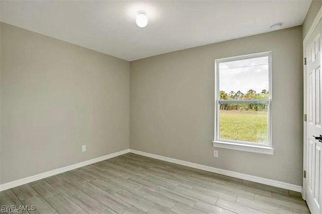 1143 Florence St E, Lehigh Acres, FL 33974 - unfurnished room featuring baseboards, plenty of natural light, and wood tiled floors