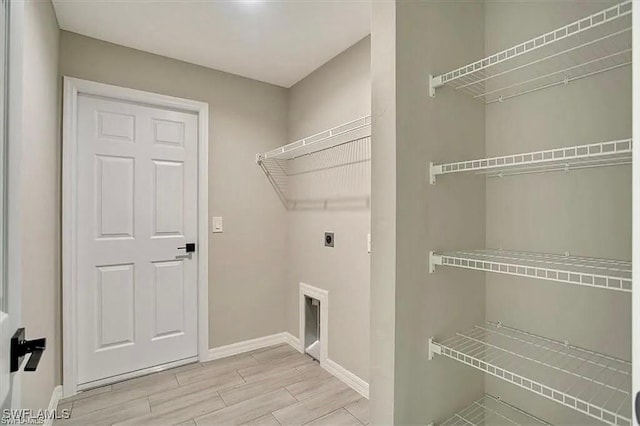 1143 Florence St E, Lehigh Acres, FL 33974 - laundry area with electric dryer hookup, wood tiled floors, and baseboards