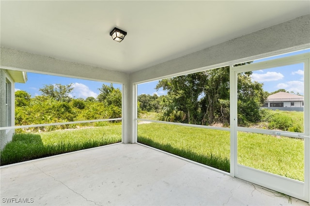 336 Ranchito Ave, Lehigh Acres, FL 33974 - unfurnished sunroom featuring view of wooded area