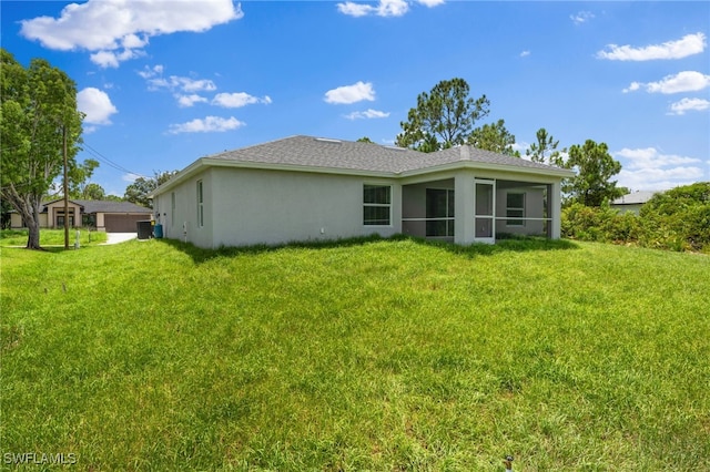 336 Ranchito Ave, Lehigh Acres, FL 33974 - back of property with a yard, central AC, stucco siding, and a sunroom