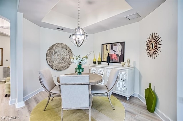 9232 Aviano Dr Unit 102, Fort Myers, FL 33913 - dining space featuring a raised ceiling, light wood finished floors, arched walkways, and baseboards