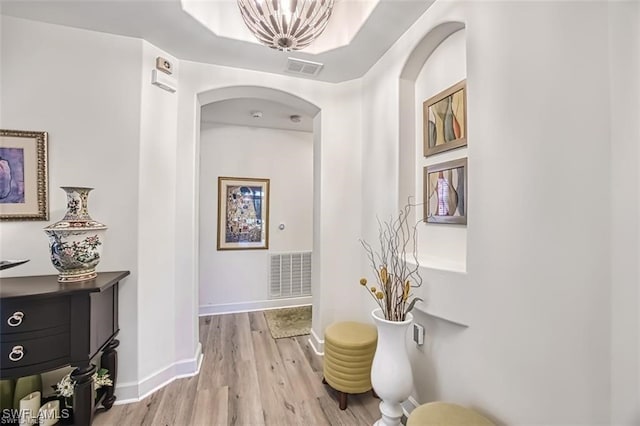 9232 Aviano Dr Unit 102, Fort Myers, FL 33913 - corridor with arched walkways, light wood-type flooring, baseboards, and a chandelier