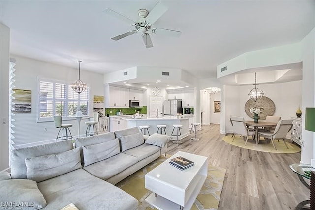 9232 Aviano Dr Unit 102, Fort Myers, FL 33913 - living room featuring a chandelier, light wood-style flooring, ceiling fan, baseboards, and recessed lighting