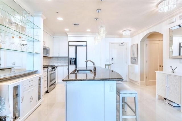 9115 Strada Pl Unit 5317, Naples, FL 34108 - kitchen with stainless steel appliances, a sink, white cabinets, arched walkways, and tasteful backsplash