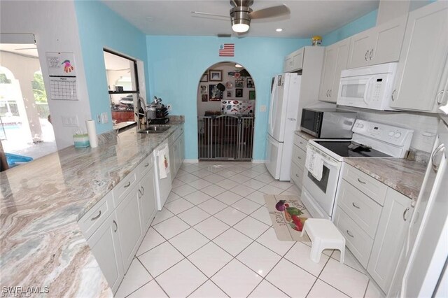 215 SE 1st Pl, Cape Coral, FL 33990 - kitchen with white appliances, a sink, arched walkways, light tile patterned floors, and ceiling fan
