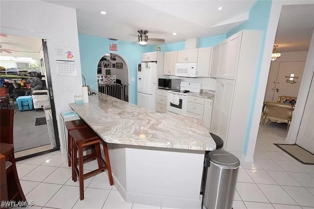 215 SE 1st Pl, Cape Coral, FL 33990 - kitchen with white appliances, ceiling fan, a kitchen bar, light stone counters, and recessed lighting