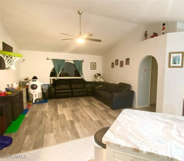 215 SE 1st Pl, Cape Coral, FL 33990 - living room featuring a ceiling fan, lofted ceiling, arched walkways, and light tile patterned floors