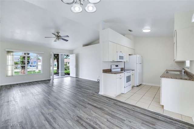 1717 43rd St SW, Naples, FL 34116 - kitchen with white appliances, vaulted ceiling, a sink, dark countertops, and open floor plan