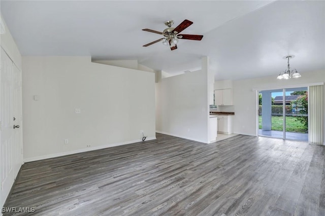 1717 43rd St SW, Naples, FL 34116 - unfurnished living room with a chandelier, wood finished floors, a ceiling fan, baseboards, and lofted ceiling