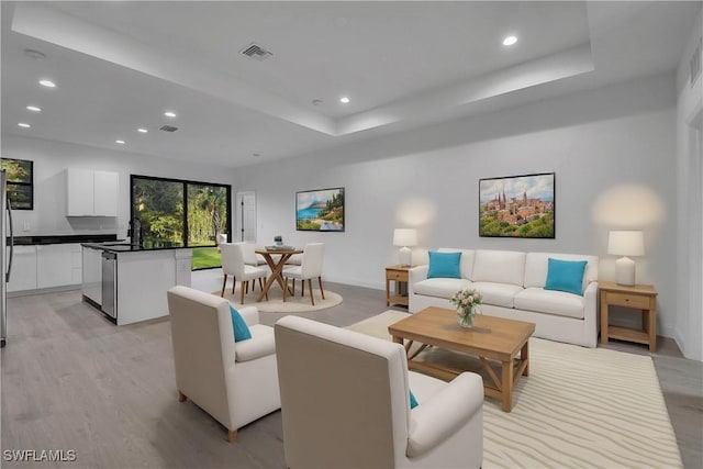 618 Sheldon Ave, Lehigh Acres, FL 33936 - living area with recessed lighting, light wood-style flooring, a tray ceiling, and baseboards