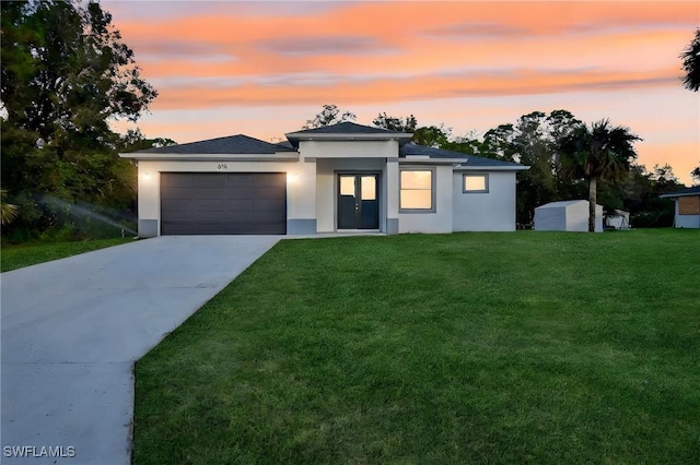 618 Sheldon Ave, Lehigh Acres, FL 33936 - prairie-style house with an attached garage, driveway, stucco siding, and a front lawn