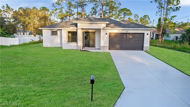 902 Magnolia Ave, Lehigh Acres, FL 33972 - prairie-style house featuring an attached garage, concrete driveway, stucco siding, and a shingled roof