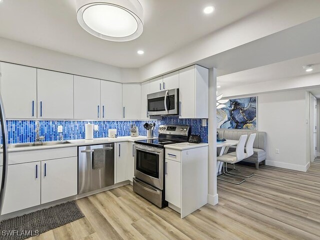 3951 Gulf Shore Blvd N Unit 1005, Naples, FL 34103 - kitchen featuring appliances with stainless steel finishes, tasteful backsplash, light countertops, light wood-style floors, and recessed lighting