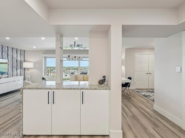 3951 Gulf Shore Blvd N Unit 1005, Naples, FL 34103 - kitchen featuring light stone countertops, light wood-style floors, baseboards, white cabinetry, and recessed lighting