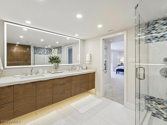 3951 Gulf Shore Blvd N Unit 1005, Naples, FL 34103 - ensuite bathroom with double vanity, a shower stall, recessed lighting, and baseboards