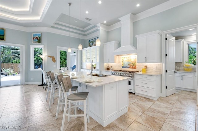 491 Wedge Dr, Naples, FL 34103 - kitchen featuring double oven range, crown molding, tasteful backsplash, a center island with sink, and white cabinetry