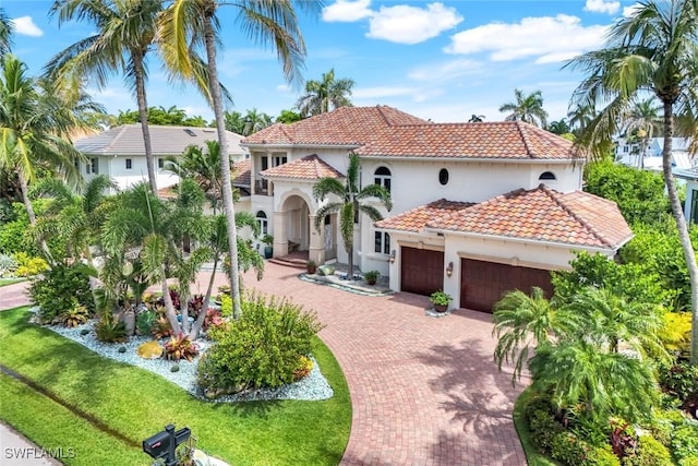 491 Wedge Dr, Naples, FL 34103 - mediterranean / spanish-style home with a garage, decorative driveway, a tile roof, and stucco siding