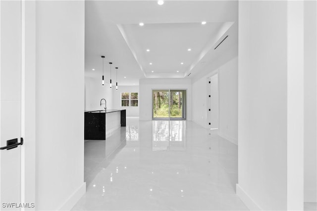 3762 32nd Ave SE, Naples, FL 34117 - hall with baseboards, recessed lighting, a tray ceiling, and light marble finish floors