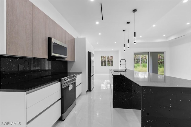 3762 32nd Ave SE, Naples, FL 34117 - kitchen with stainless steel appliances, modern cabinets, a spacious island, a sink, and dark countertops