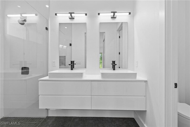 3762 32nd Ave SE, Naples, FL 34117 - bathroom featuring double vanity, toilet, a walk in shower, and tile patterned floors