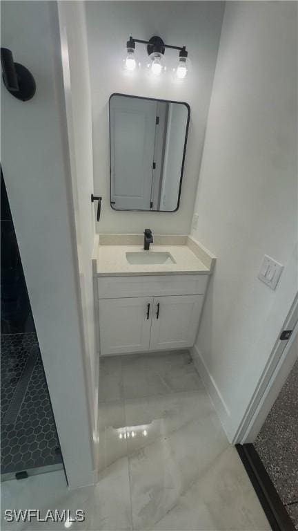 761 Bell Blvd S, Lehigh Acres, FL 33974 - bathroom with vanity, baseboards, a tile shower, and marble finish flooring