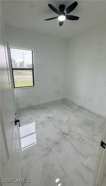 761 Bell Blvd S, Lehigh Acres, FL 33974 - unfurnished room featuring marble look tiles, baseboards, and ceiling fan
