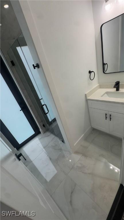 761 Bell Blvd S, Lehigh Acres, FL 33974 - bathroom with marble finish flooring, vanity, and baseboards