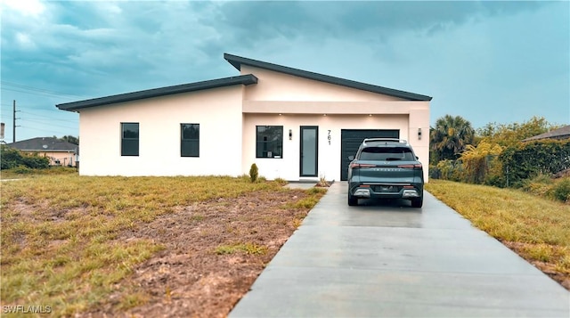 761 Bell Blvd S, Lehigh Acres, FL 33974 - view of front of house with driveway, stucco siding, an attached garage, and a front yard