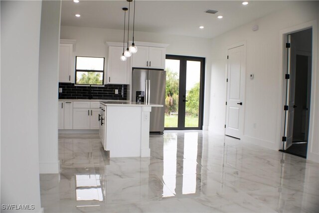 761 Bell Blvd S, Lehigh Acres, FL 33974 - kitchen with light marble finish floors, stainless steel fridge, plenty of natural light, and recessed lighting