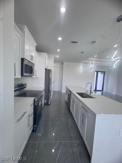 31 Kismet Pkwy E, Cape Coral, FL 33909 - kitchen featuring stainless steel appliances, a sink, a spacious island, white cabinetry, and dark marble finish floors