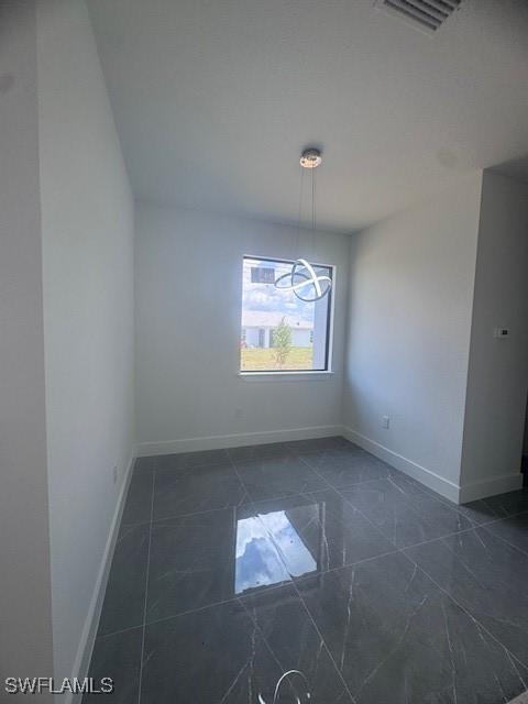 31 Kismet Pkwy E, Cape Coral, FL 33909 - spare room featuring baseboards and dark marble finish flooring