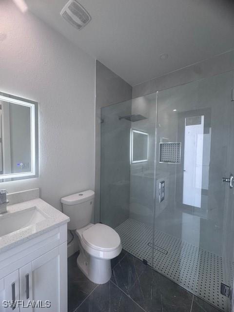 31 Kismet Pkwy E, Cape Coral, FL 33909 - bathroom with vanity, a shower stall, toilet, and marble look tiles