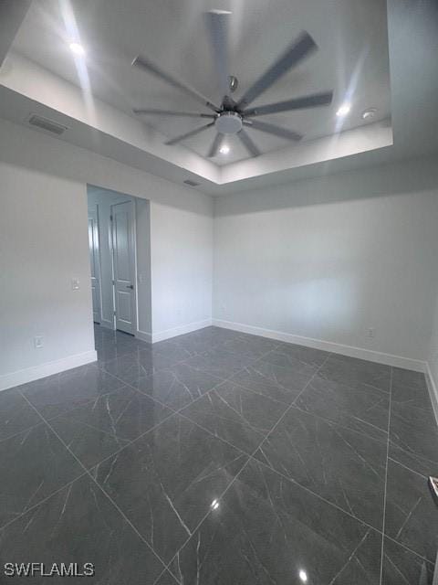 31 Kismet Pkwy E, Cape Coral, FL 33909 - empty room featuring a raised ceiling, ceiling fan, baseboards, and dark marble finish floors